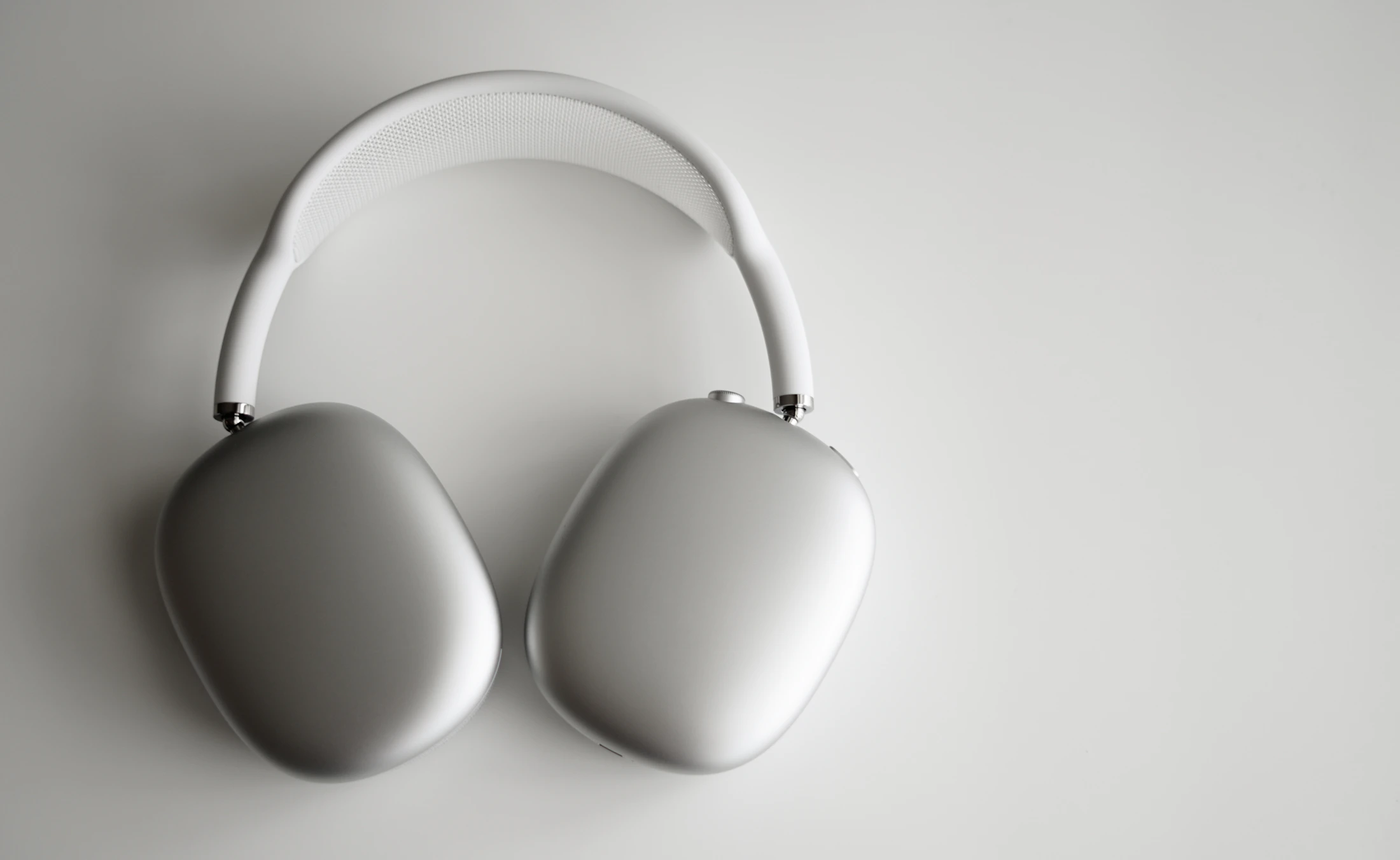 Silver over-ear headphones on a neutral surface